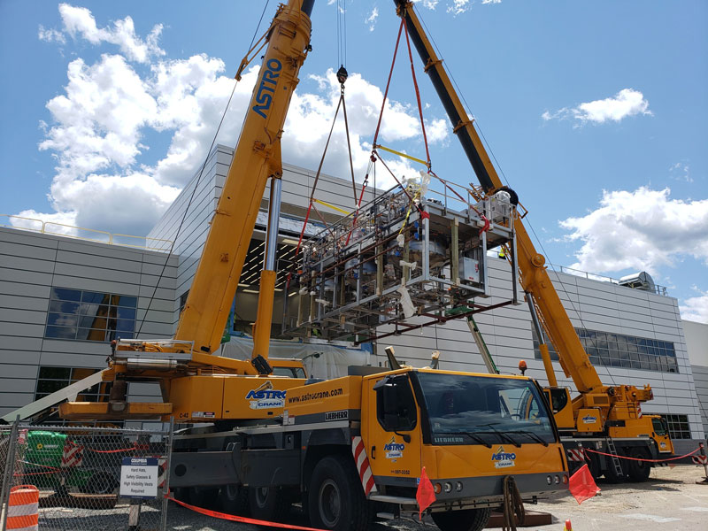 cranes installing equipment into a building